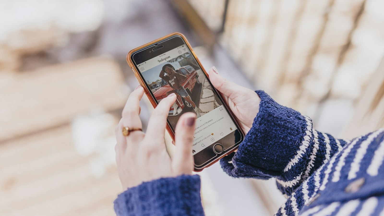 Mains tenant un smartphone affichant un profil Instagram